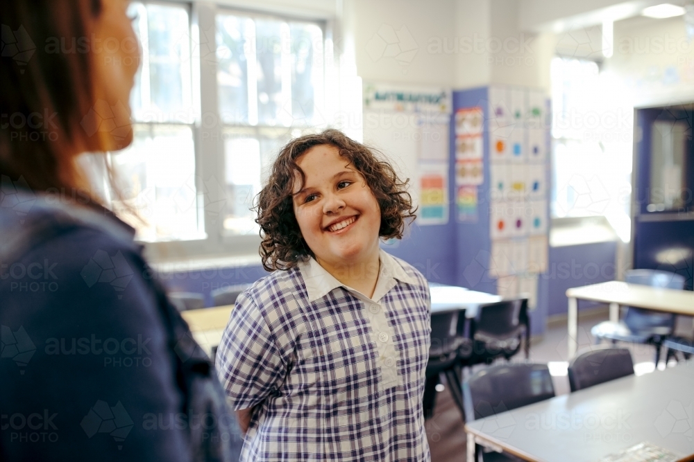 Girl primary school student with her female teacher in the classroom at school - Australian Stock Image