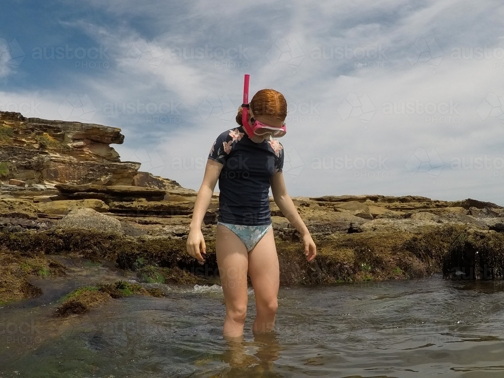 Girl reading to go snorkelling - Australian Stock Image