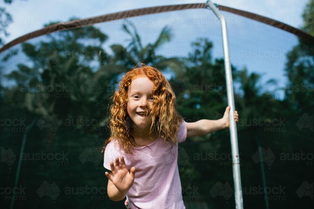 Girl ready to jump from the edge of a trampoline - Australian Stock Image