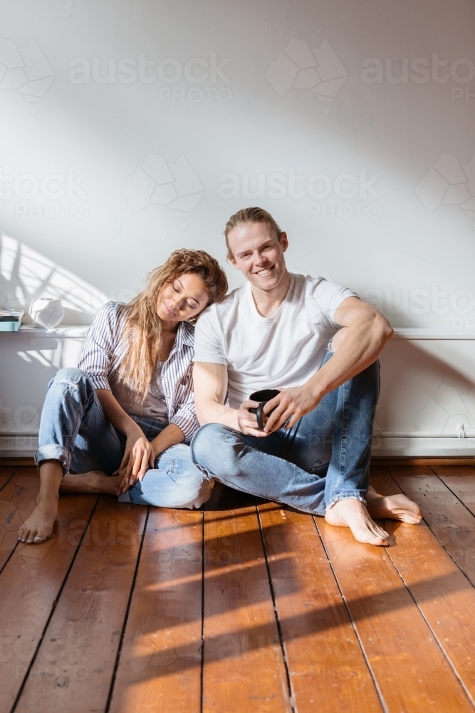Girl resting her head on the shoulder of a guy looking at camera - Australian Stock Image