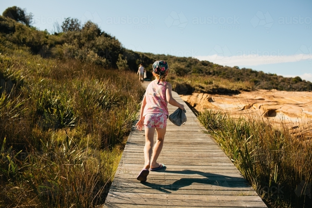 Girl running along a boardwalk at the beach - Australian Stock Image