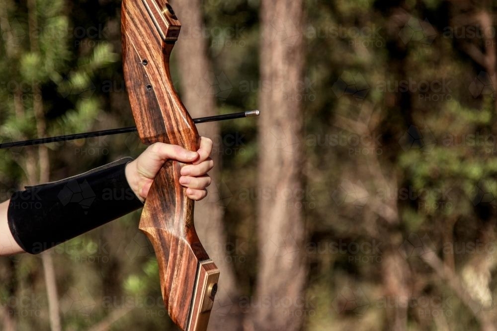 Girl shooting an arrow with a takedown recurve bow - Australian Stock Image