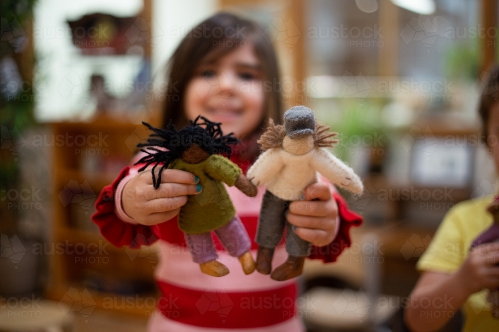 Girl showing international felt dolls - Australian Stock Image