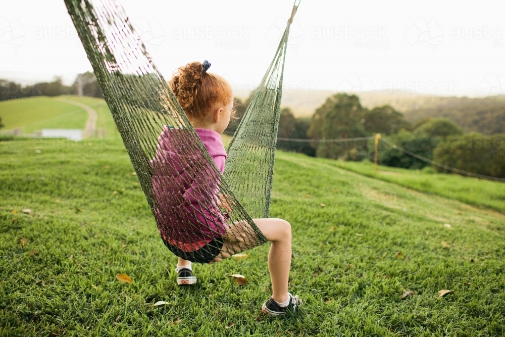 Girl sitting in a string hammock - Australian Stock Image