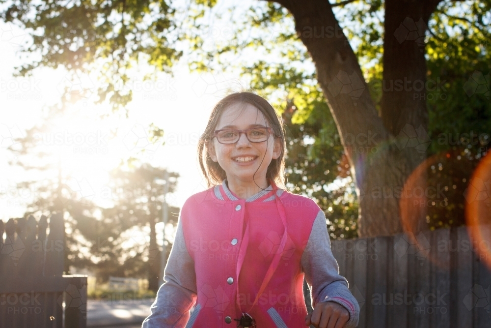 Girl smiling and walking toward camera at dusk - Australian Stock Image