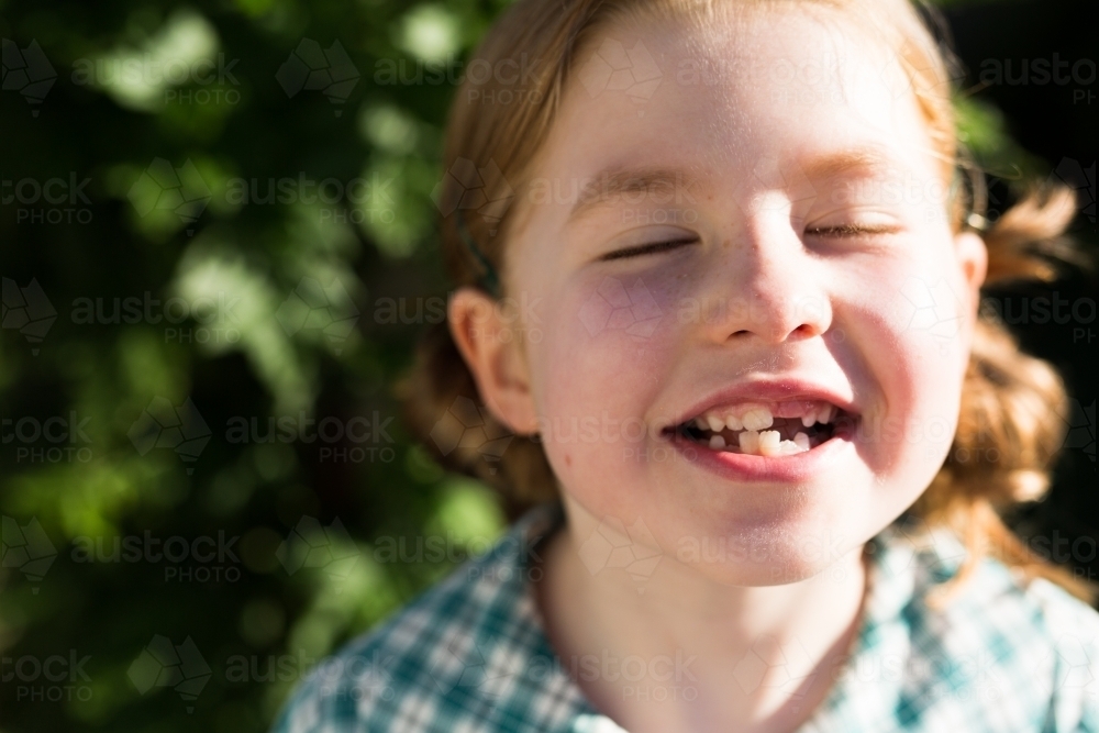 girl smiling in the sunlight - Australian Stock Image