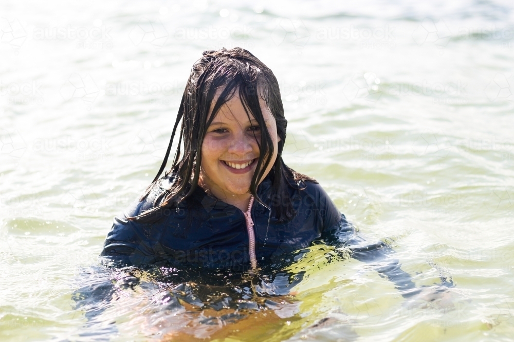 Image of Girl smiling while standing in the sea - Austockphoto
