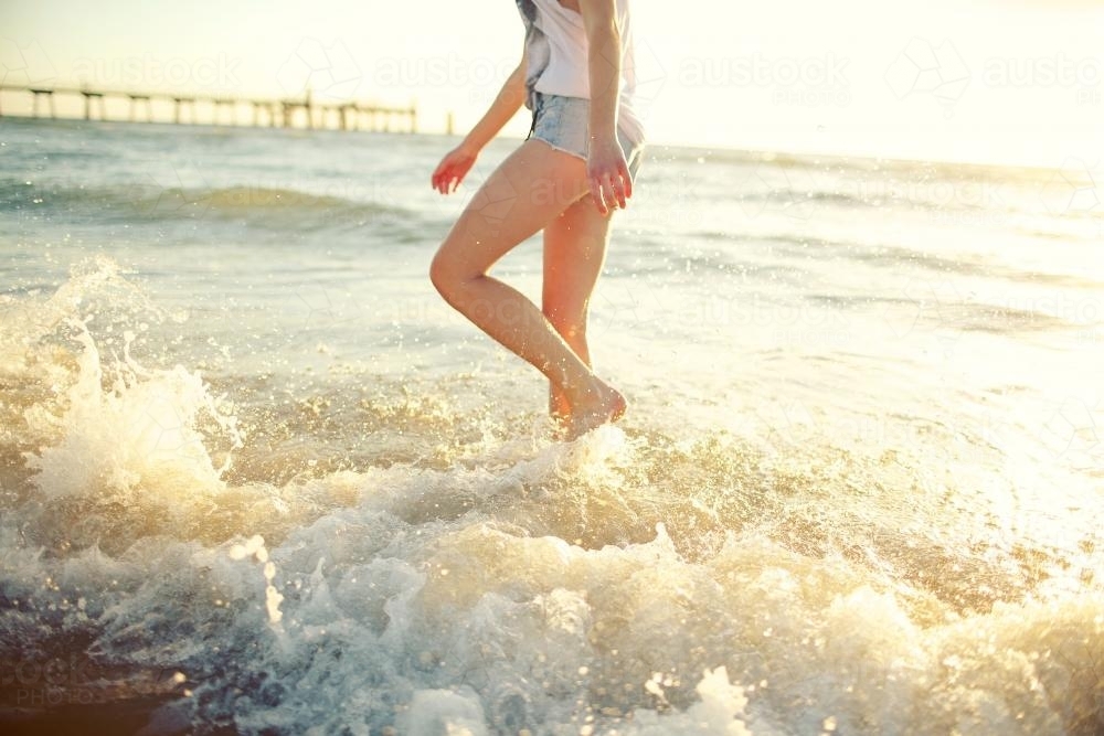 Girl splashing on a beach - Australian Stock Image