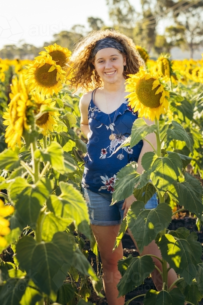 Girl standing in sunflower field - Australian Stock Image