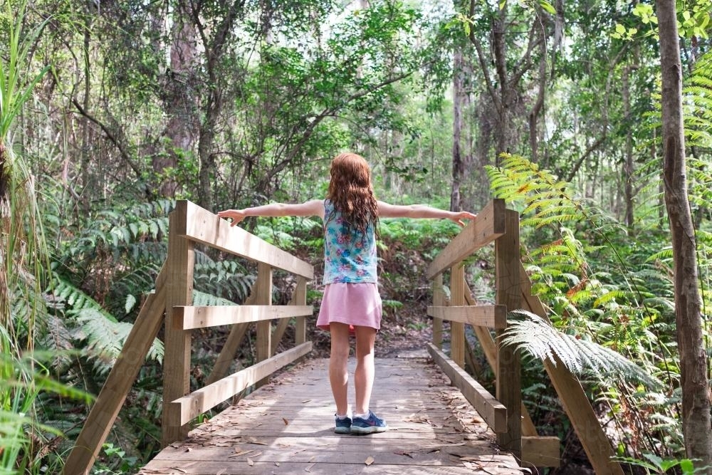 Girl standing on a wooden bridge in the bush - Australian Stock Image
