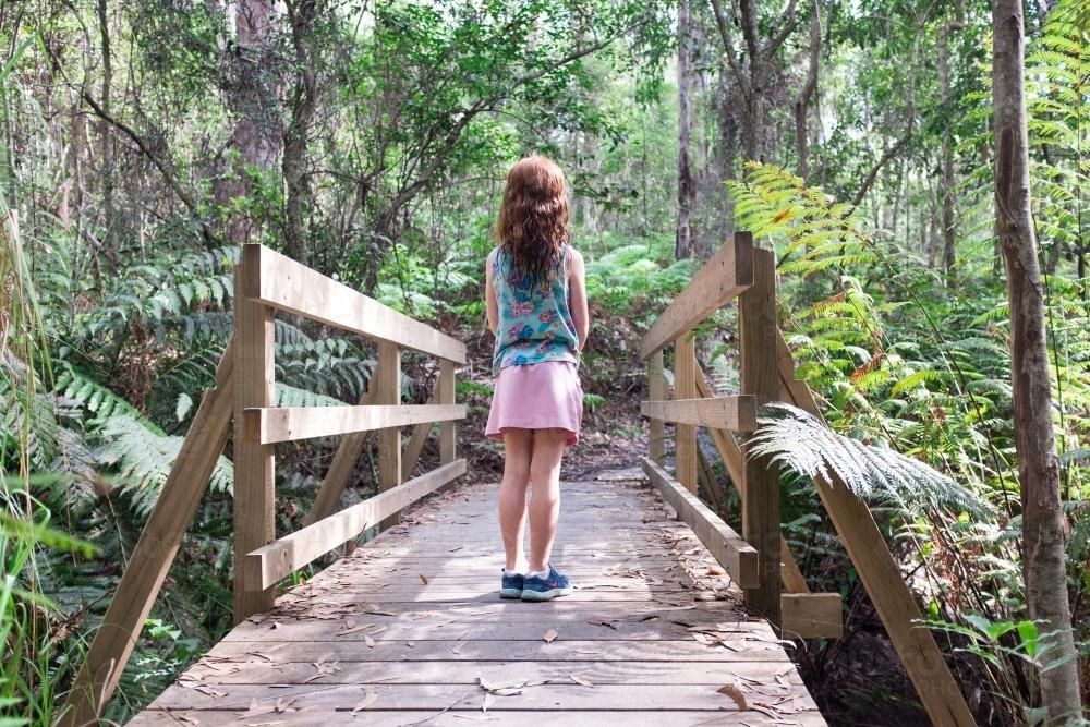 Girl standing on a wooden bridge in the bush - Australian Stock Image