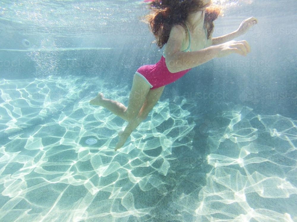 Girl swimming underwater in a pool - Australian Stock Image