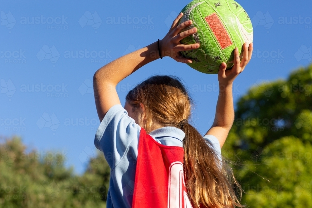 Image of Girl throwing netball from behind - Austockphoto