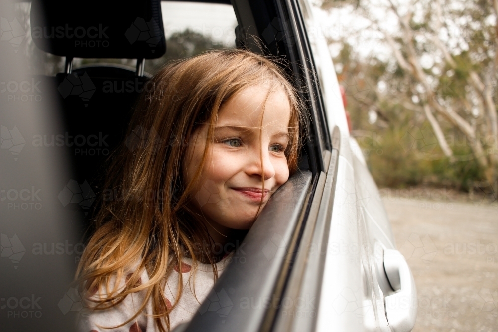 Girl traveling through country looking out car window - Australian Stock Image