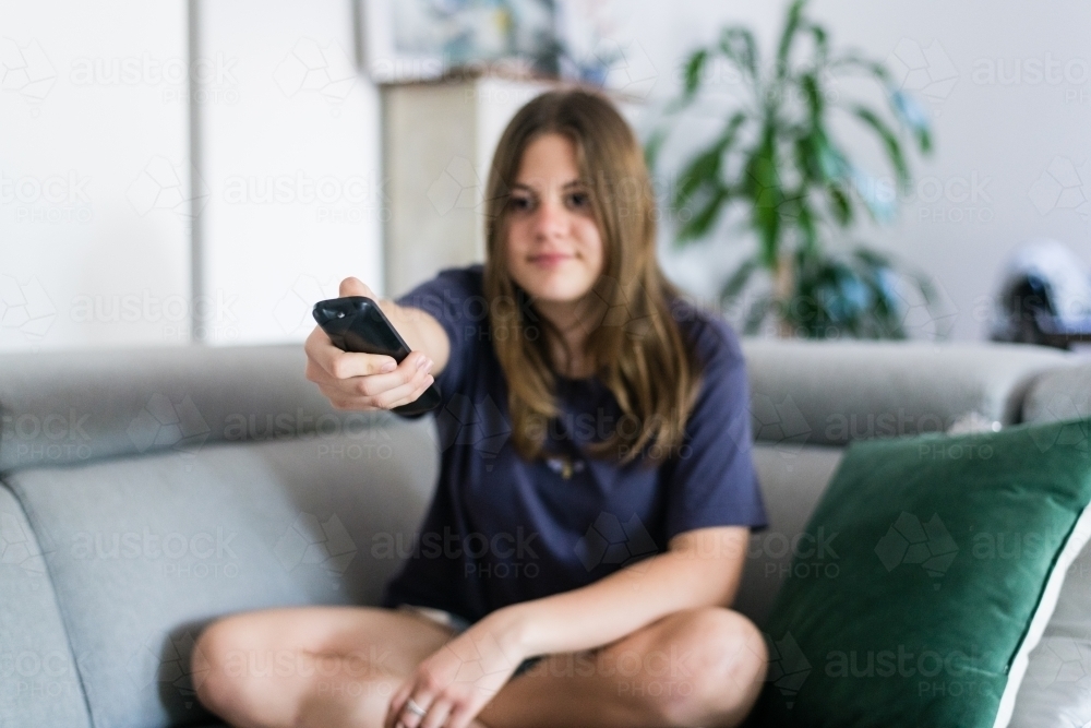 Image of girl using remote control - Austockphoto