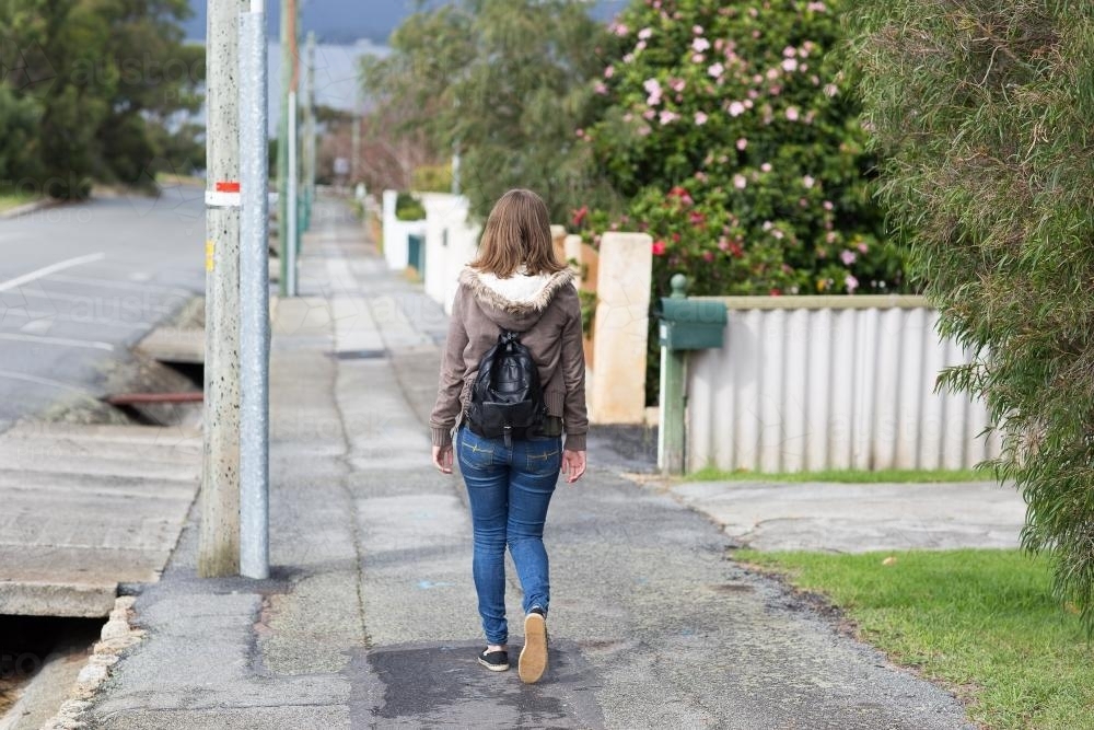 girl walking away along footpath - Australian Stock Image