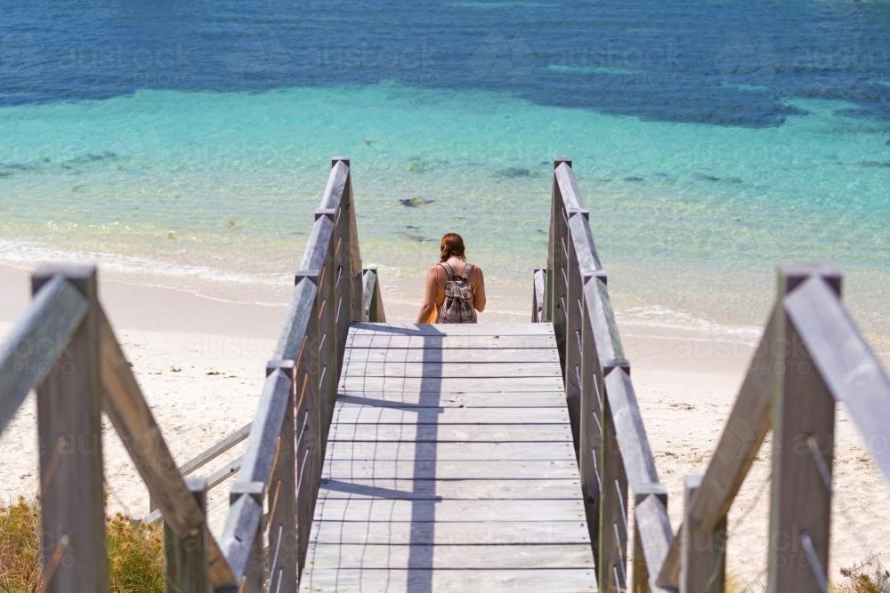 Girl walking down steps to the beach - Australian Stock Image