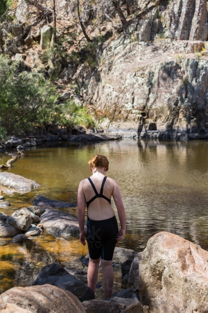 Girl walking to a waterhole in inland Australia - Australian Stock Image