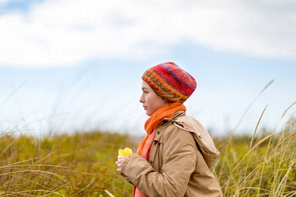 Girl wearing a beanie, scarf and jacket in paddock - Australian Stock Image