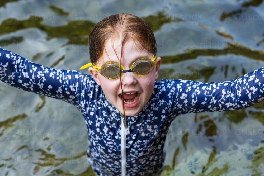 Girl wearing goggles and a rashie in a waterhole - Australian Stock Image