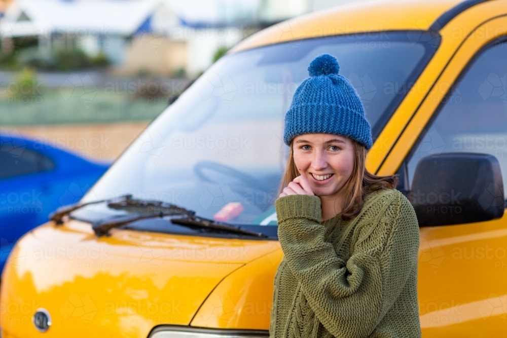 girl wearing knitted beanie in front of yellow van - Australian Stock Image
