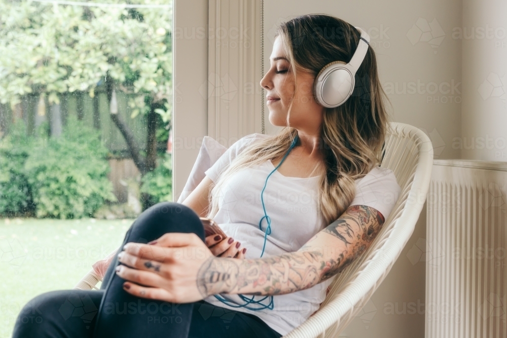 Girl with eyes closed listening to music with headphones on - Australian Stock Image