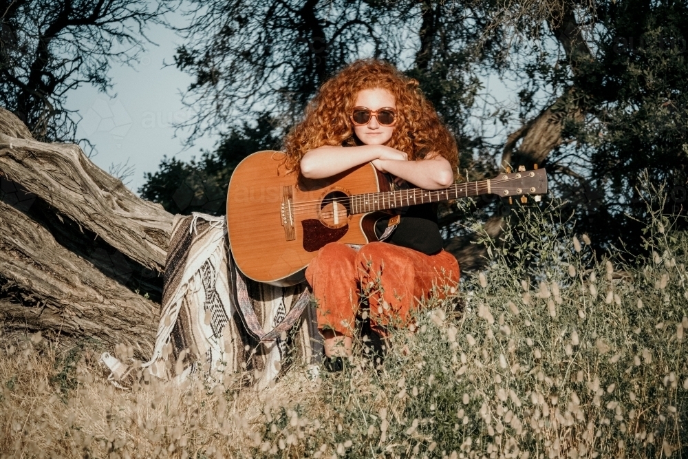 Girl with guitar and great curly red hair. - Australian Stock Image