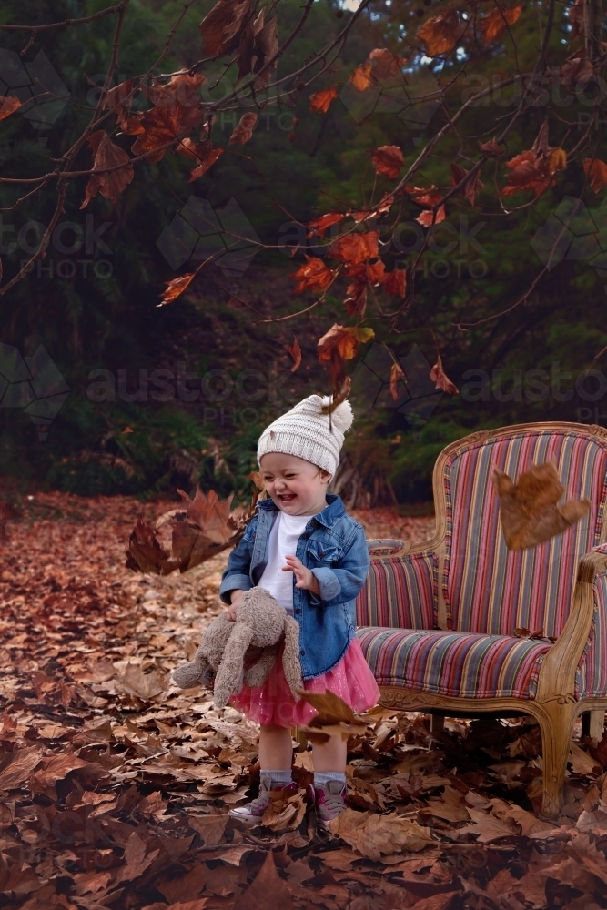 Girl With Hat Playing in Autumn Leaves - Australian Stock Image