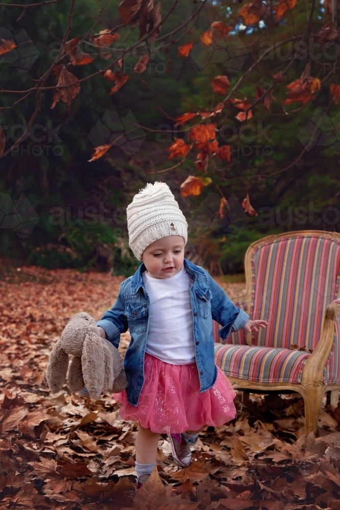 Girl With Hat Running in Autumn Leaves - Australian Stock Image