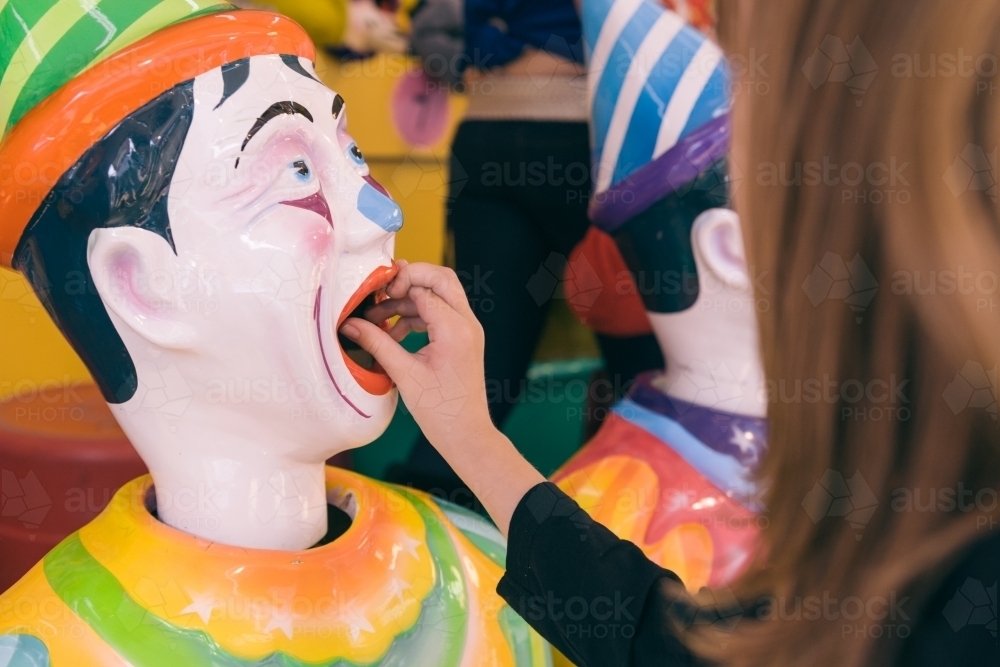 girl with her fingers crossed as she plays a game at a fun fair - Australian Stock Image