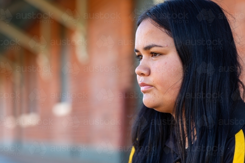 girl with neutral expression looking across the frame - Australian Stock Image