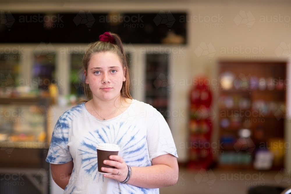 Girl with takeaway cup in roadhouse cafe - Australian Stock Image