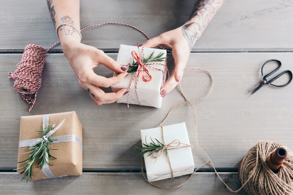 Girl with tattoos wrapping beautiful Christmas presents - Australian Stock Image