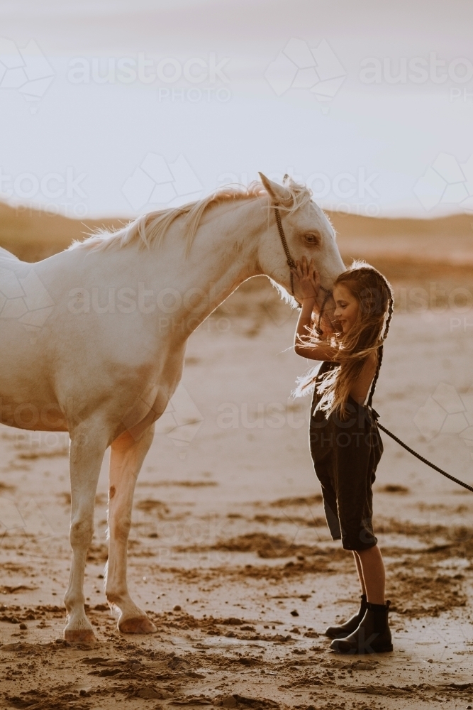 Girl with white horse on the beach at sunset - Australian Stock Image