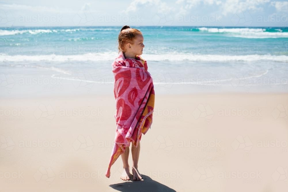 Girl wrapped in a towel at the beach - Australian Stock Image