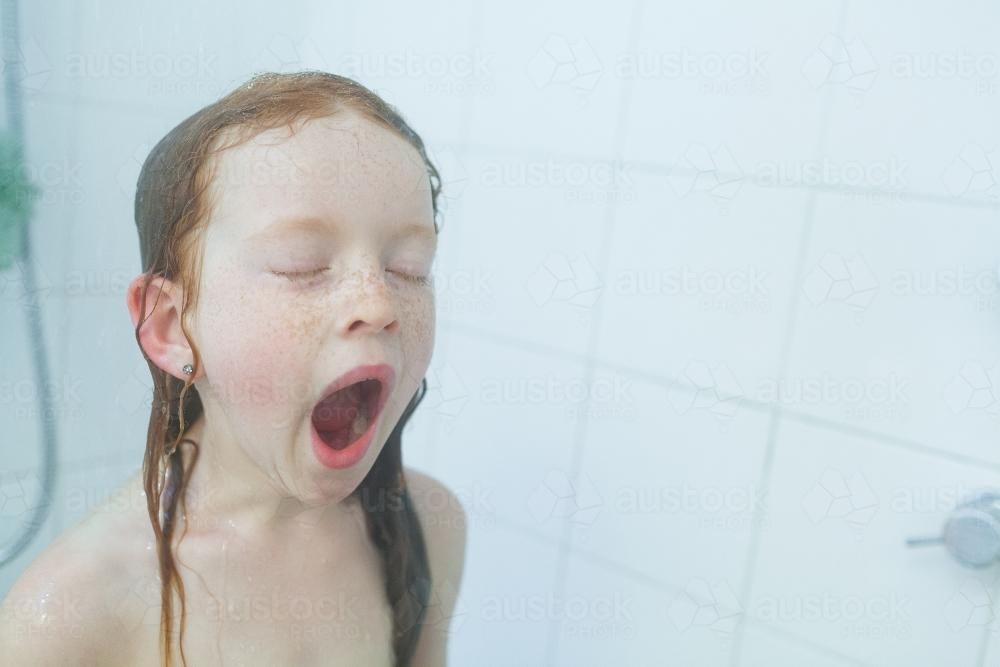 Girl yawning in the shower - Australian Stock Image