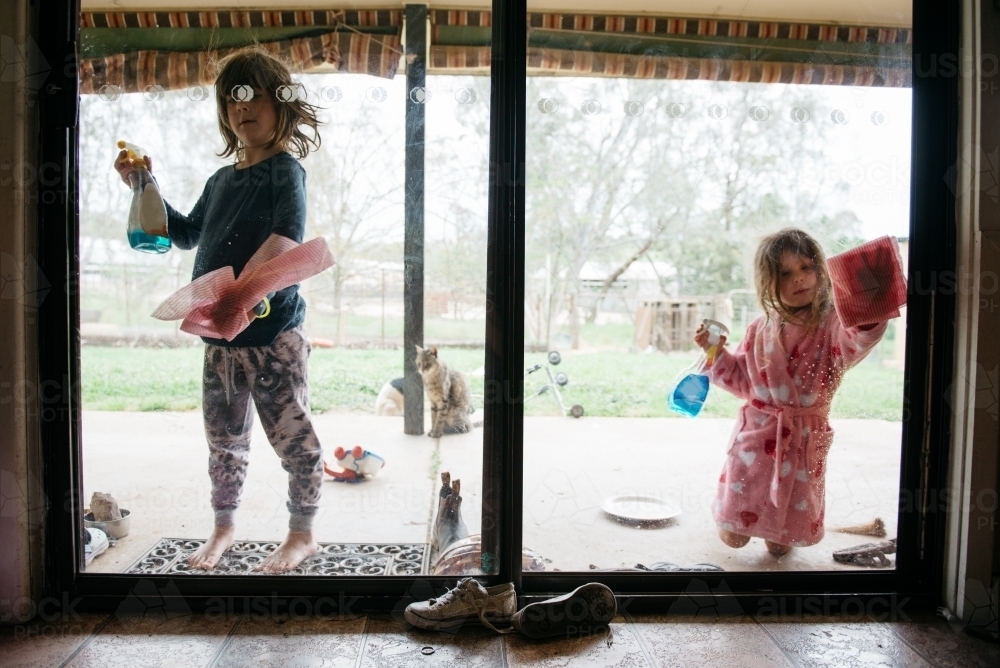 Girls cleaning windows - Australian Stock Image