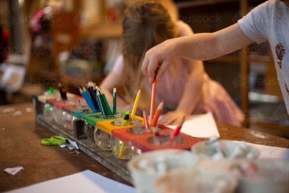 Girls drawing with coloured pencils in an early education setting - Australian Stock Image