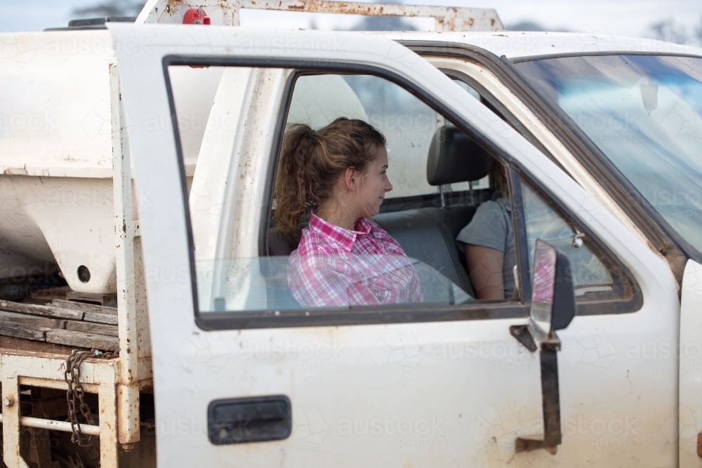Girls in farm ute with water tank on the back - Australian Stock Image