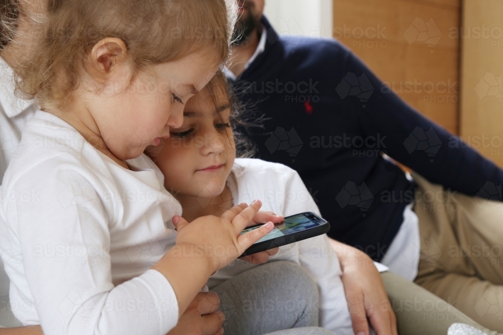 Girls looking at phone - Australian Stock Image