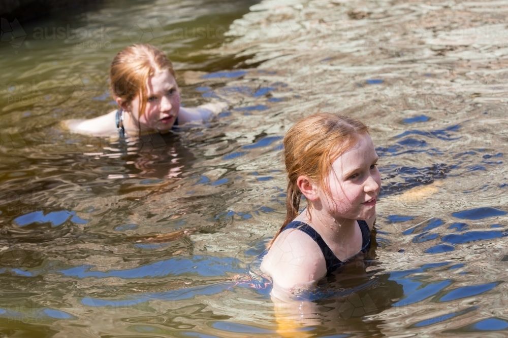 Girls swimming in a waterhole in inland Australia - Australian Stock Image