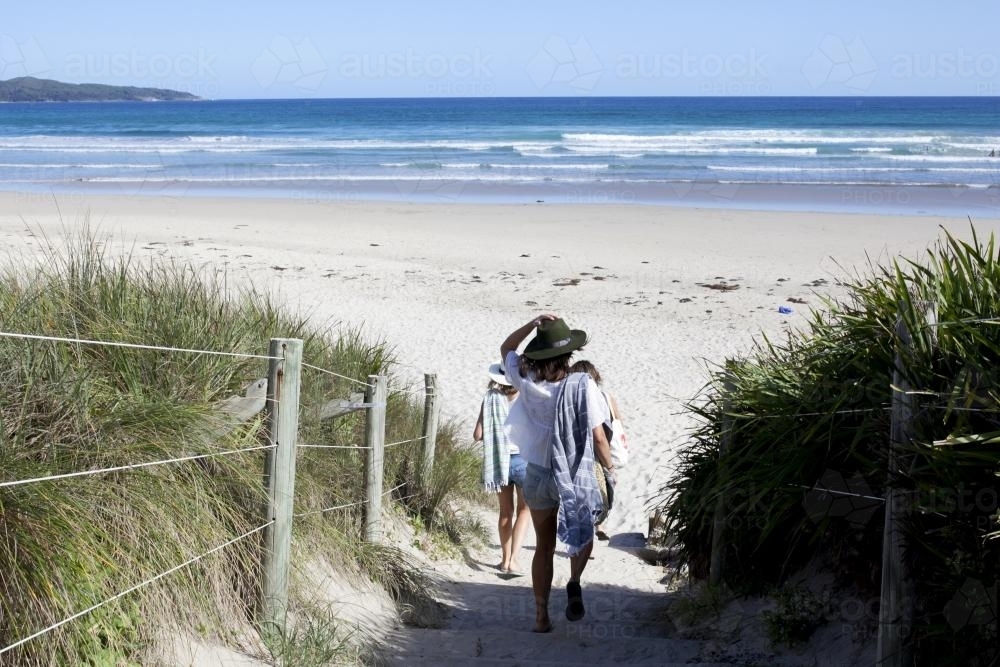 Girls walking down to empty beach - Australian Stock Image