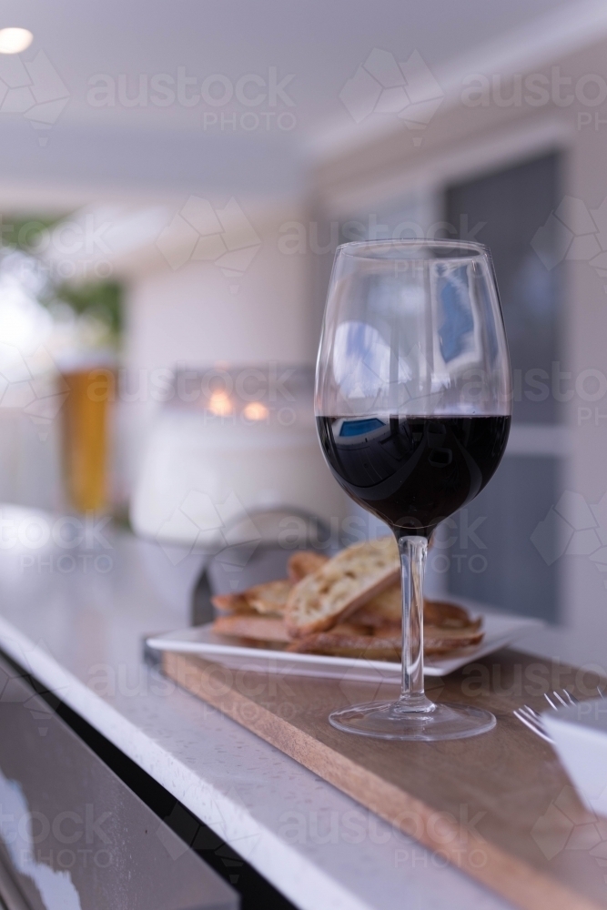 Glass of red wine and small plate of sourdough bread - Australian Stock Image