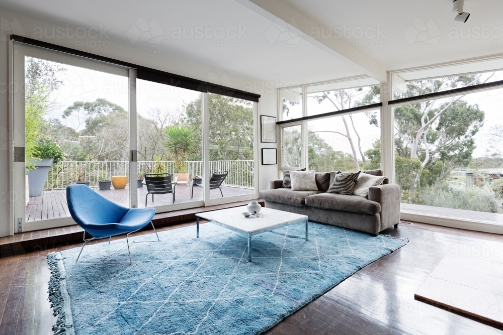 Glassed wall Australian living room with amazing views of bush treetops - Australian Stock Image