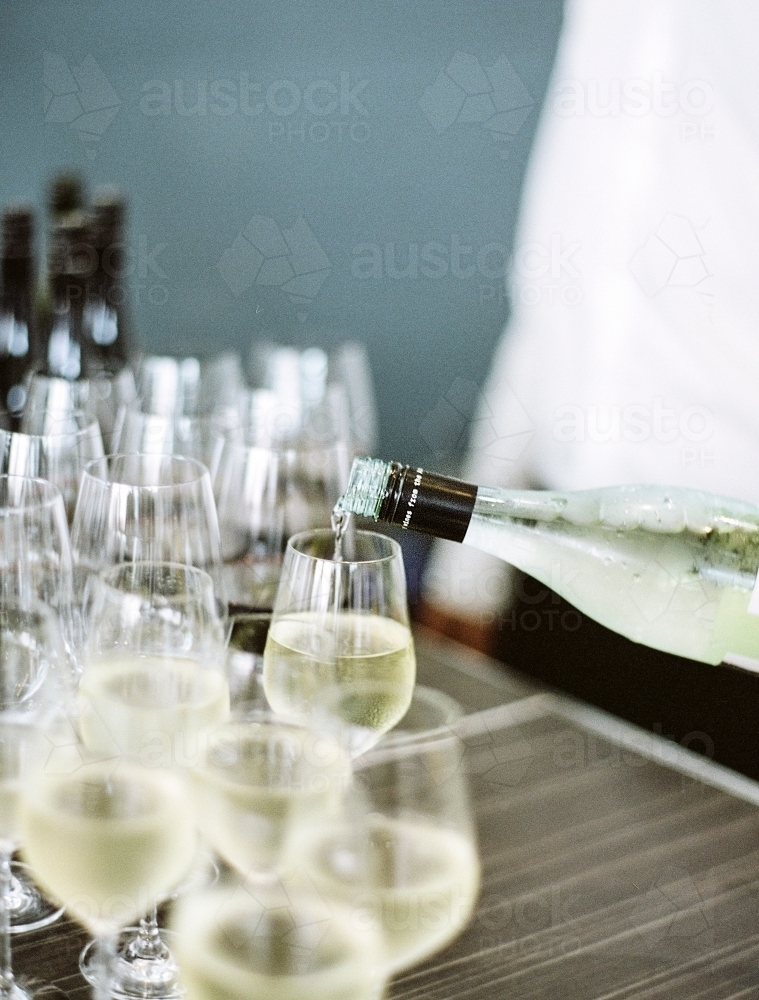 Glasses of wine being poured at a wedding - Australian Stock Image