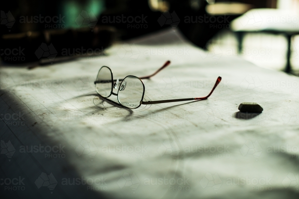 Glasses sitting on technical plans - Australian Stock Image