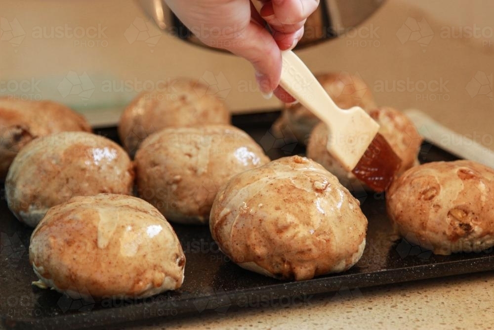 Glazing hot cross buns - Australian Stock Image