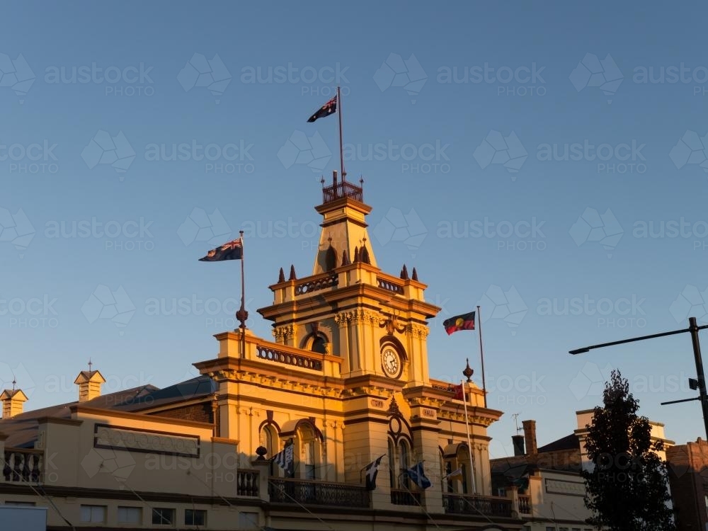 Glen Innes town hall in late afternoon sun and flags flying - Australian Stock Image