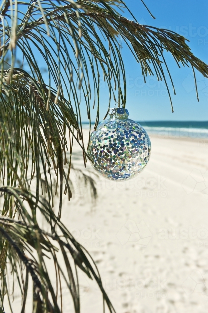 Glitter christmas ornament hanging in a tree at the beach - Australian Stock Image