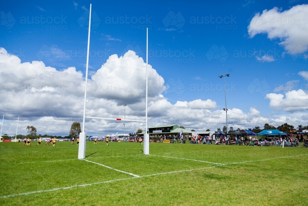 Goal posts of sports field with crowd of spectators watching the team play - Australian Stock Image